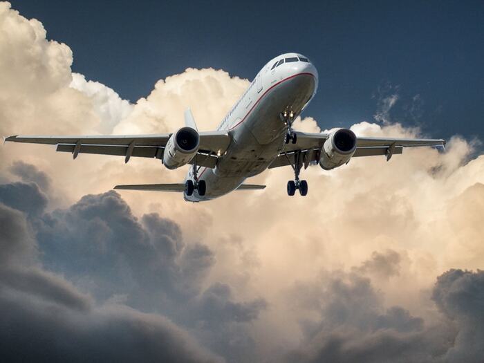 Großes Passagierflugzeug im Landeanflug vor dramatischem Wolkenhimmel